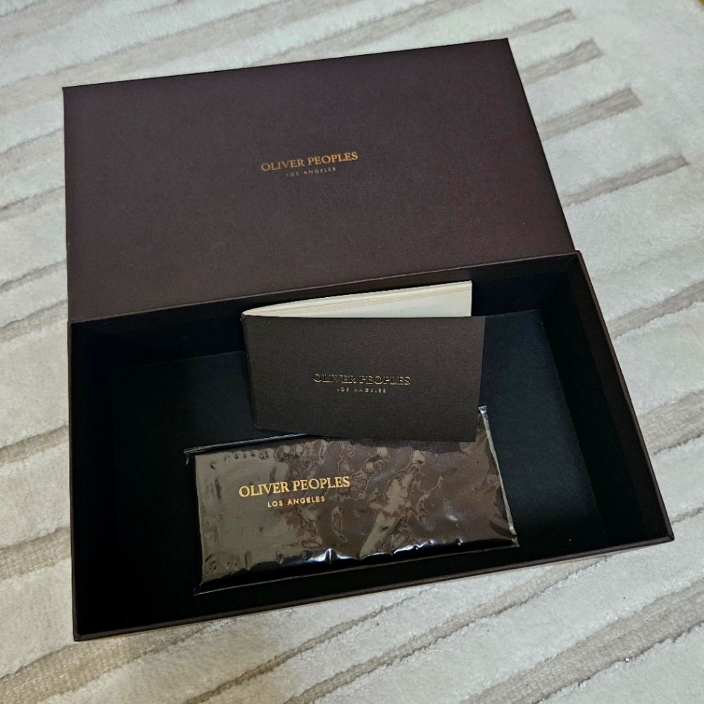 Oliver Peoples Los Angeles empty sunglasses box, booklet, and cleaning cloth